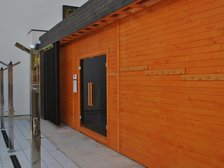 Zewnętrzna duża sauna fińska, a przed wejściem do niej trzy poczwórne prysznice zewnętrzne.