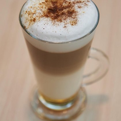 Kawa latte z pianką, posypana cynamonem. 