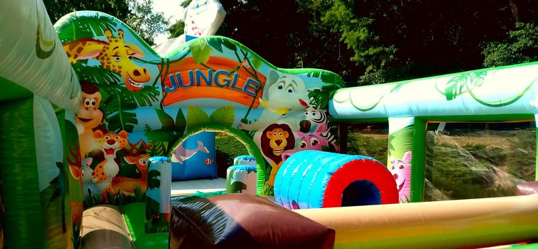 Wnętrze dmuchanego placu zabaw Dżungla. Kolorowy tor przeszkód złożony z dmuchanych bramek i tuneli. 
