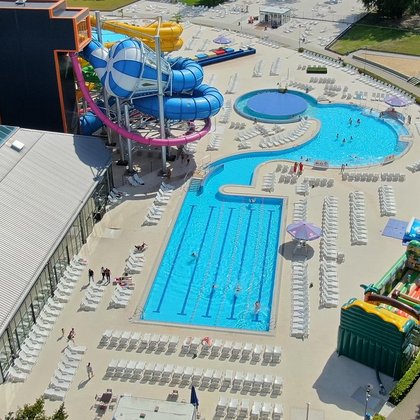 Panorama terenu zewnętrznego Strefy Basenowej z perspektywy drona - widać zewnętrzny basen sportowy. 
