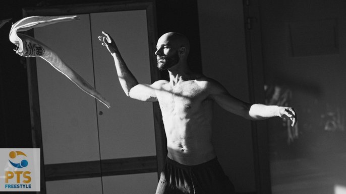 Czarno-białe zdjęcie, na którym znajduje się saunamistrz Paweł Wątorek. Mężczyzna jest bez koszulki, ma spodenki. Ujęcie pokazuje jak mężczyzna macha ręcznikiem. 