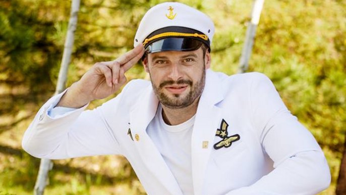 Mężczyzna w stroju inspirowanym białym mundurem marynarskim w charakterystycznej dla niego białej czapce. 